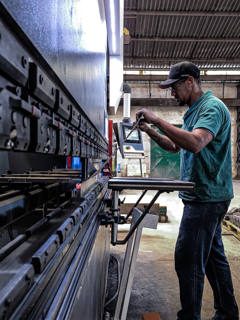 Gerente de operaciones de planta manufacturera colombiana revisando datos de inventario en una tablet